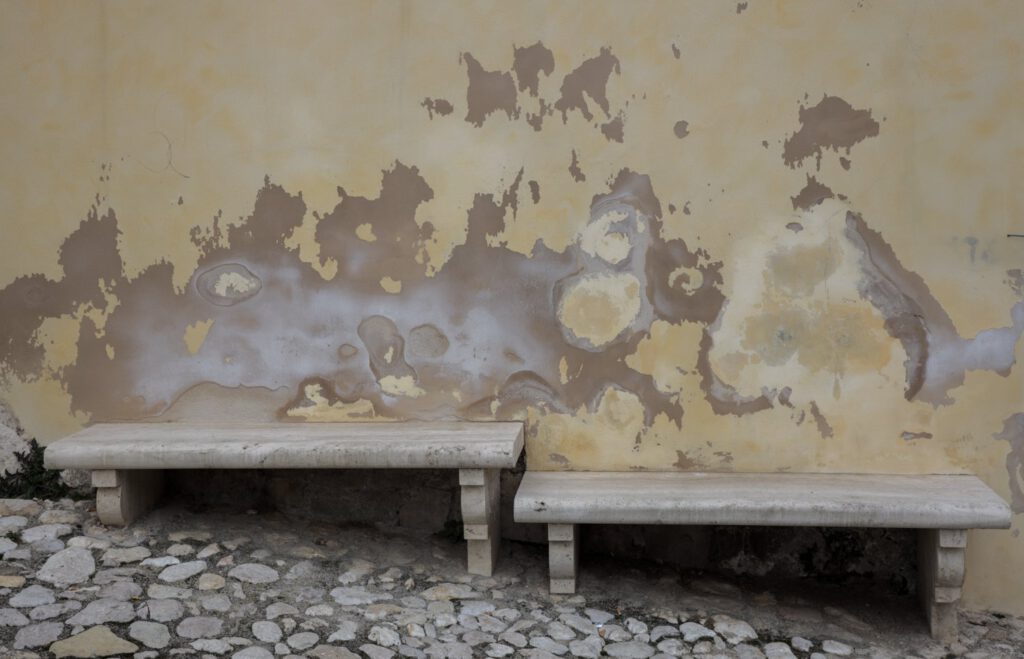 Zwei Marmorbänke vor Hauswand mit abgeblättertem Putz - copyright Mareen Malessa